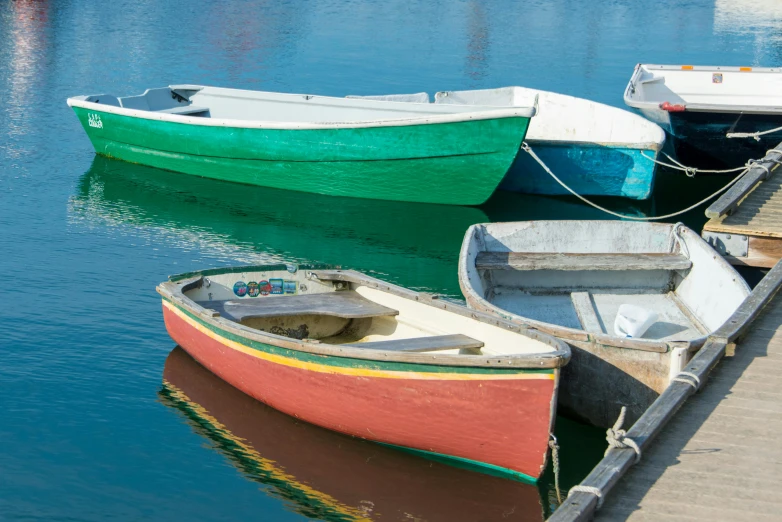 a pier with small boats and larger ones in it