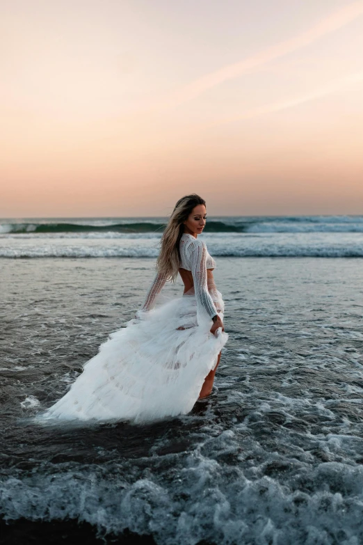 a woman wearing a white dress in the ocean