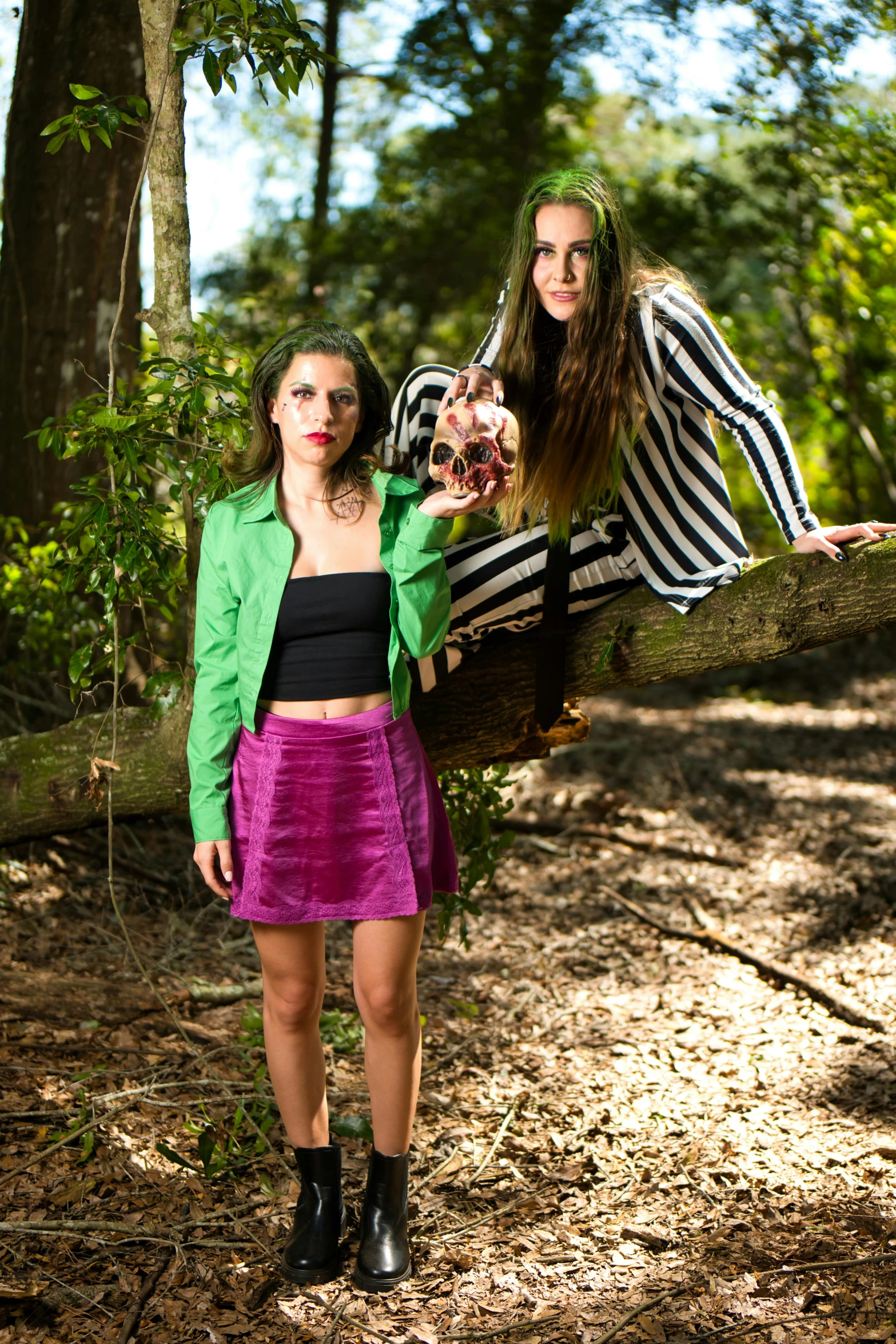 two woman posing on a tree nch with their hands in the air