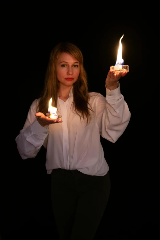 girl holding three lit candles in both hands