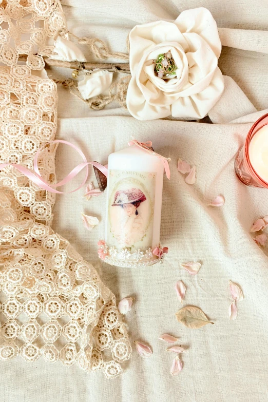 pink candles on a bed with white linen