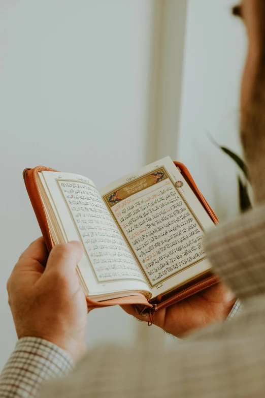 a man holding an open book with writing on it