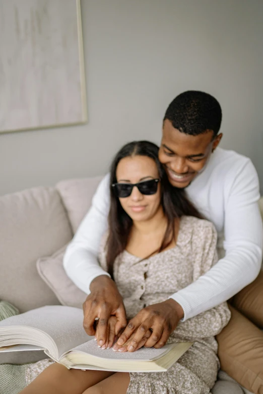 a couple reading a book together on a couch