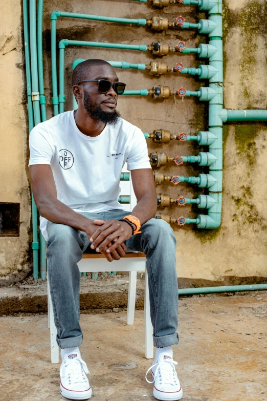 a black man in white is sitting on a bench