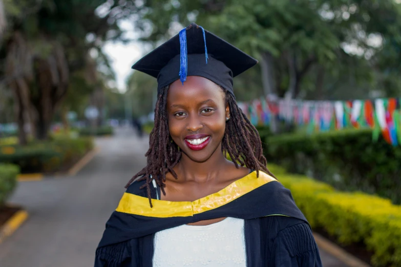 the smiling graduate is wearing her black hat