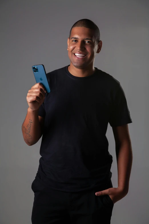 a man holding an mp3 player smiling for a po