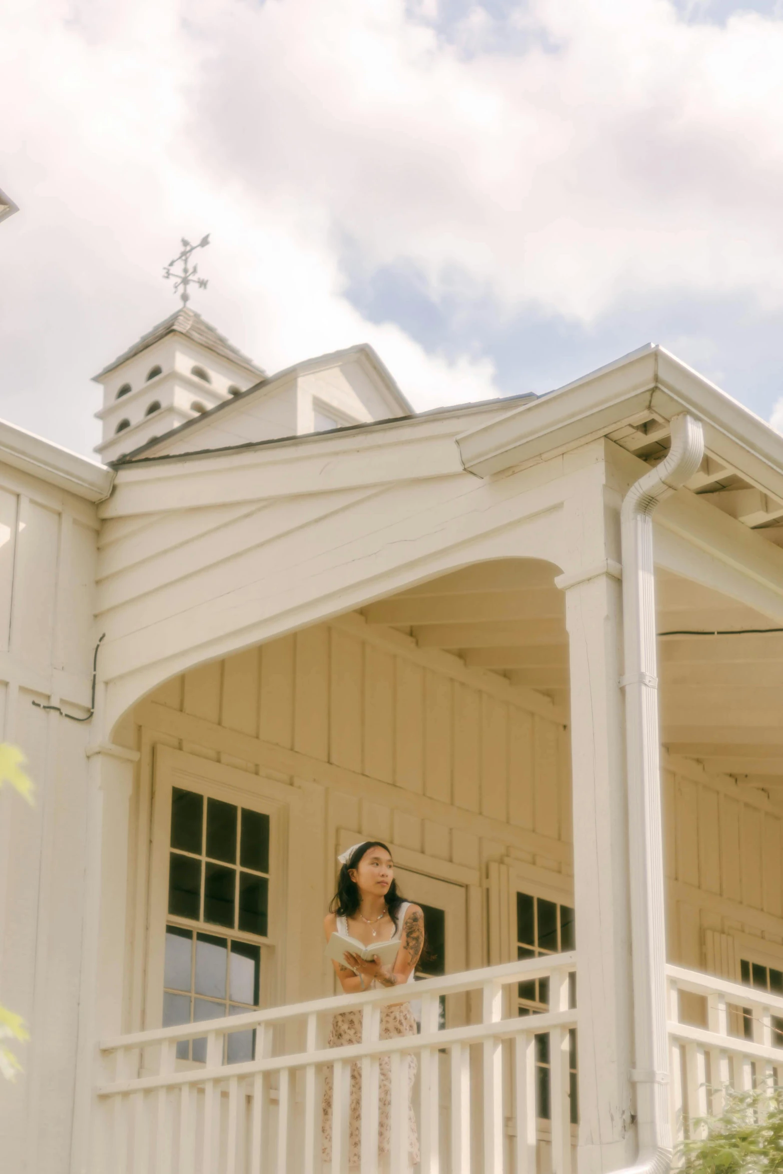 a woman looking down while standing on a porch