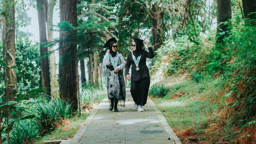 two woman walking down a path through the woods together