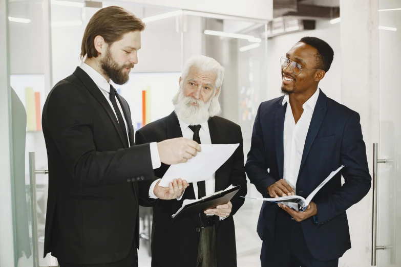 there is a man standing in a suit talking to three other men