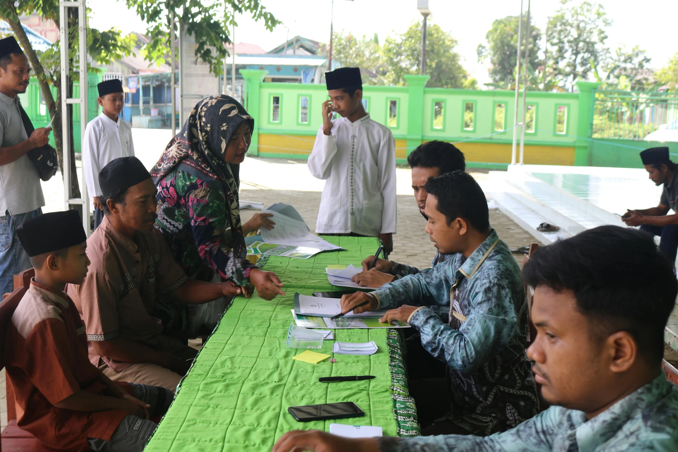 a number of people sitting at a table writing