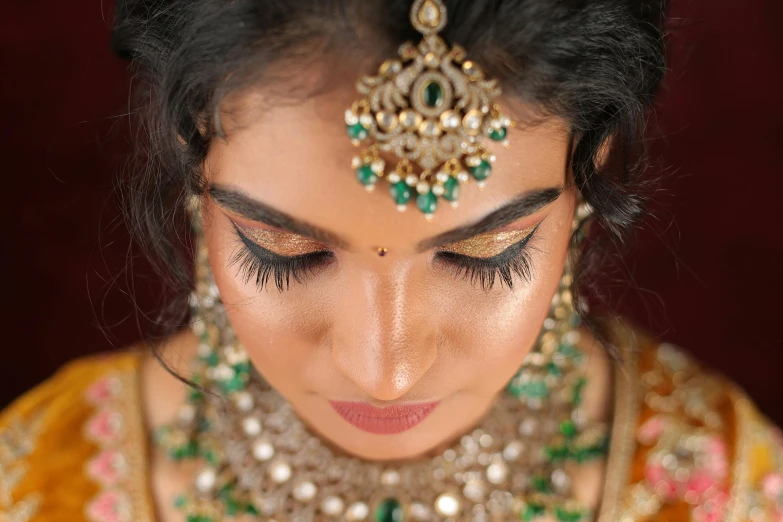 close up of woman wearing a bridal outfit with multiple pieces of jewelry