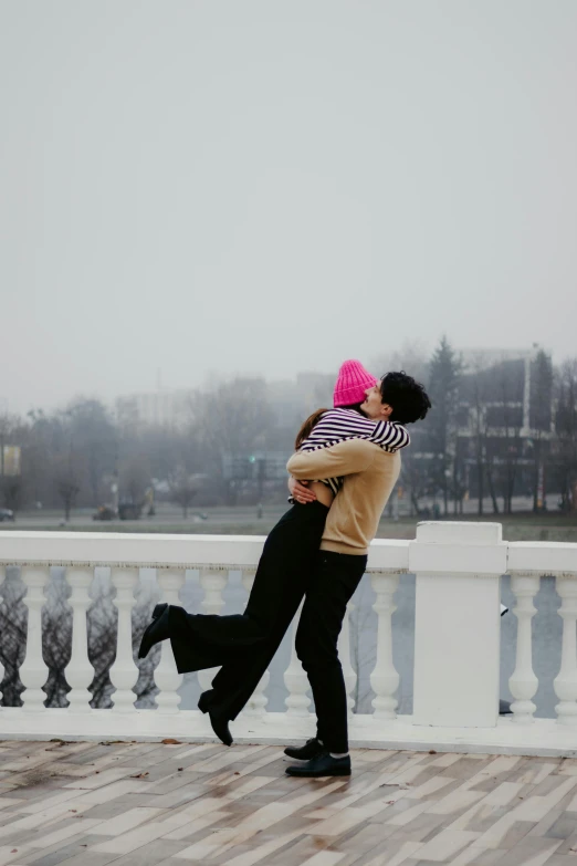 a man and woman walking along a walkway under an umbrella