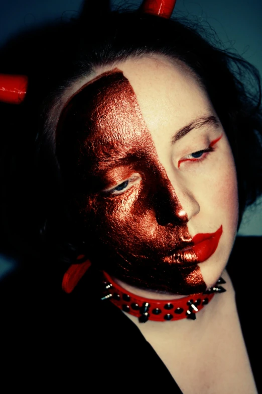 a woman with red lipstick and horns has her face painted