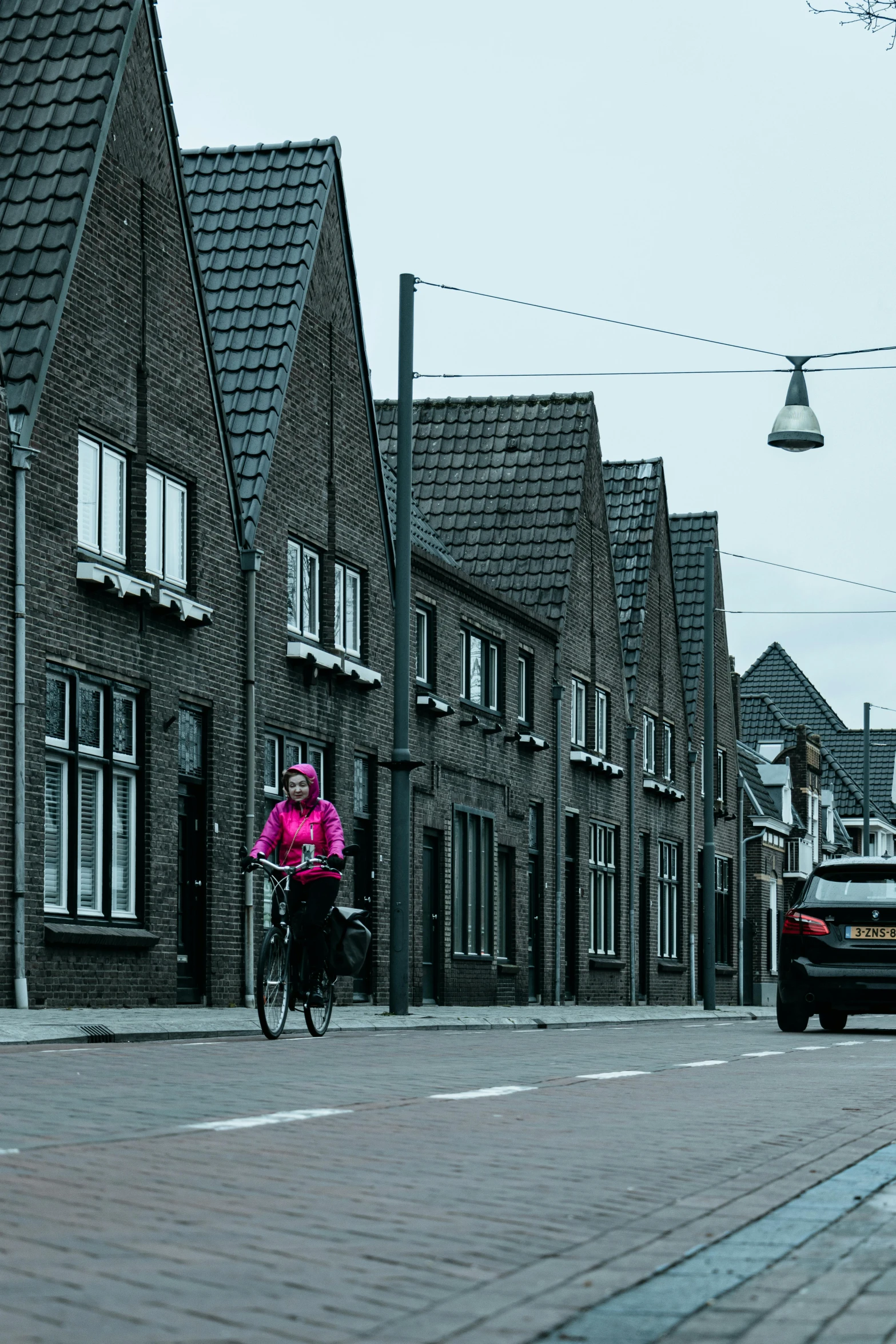 a woman riding a bike in front of some brick buildings