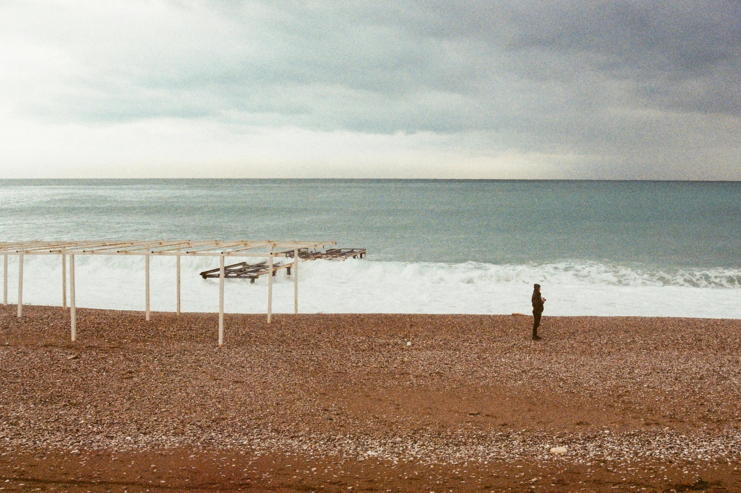 a person standing on a beach near the ocean