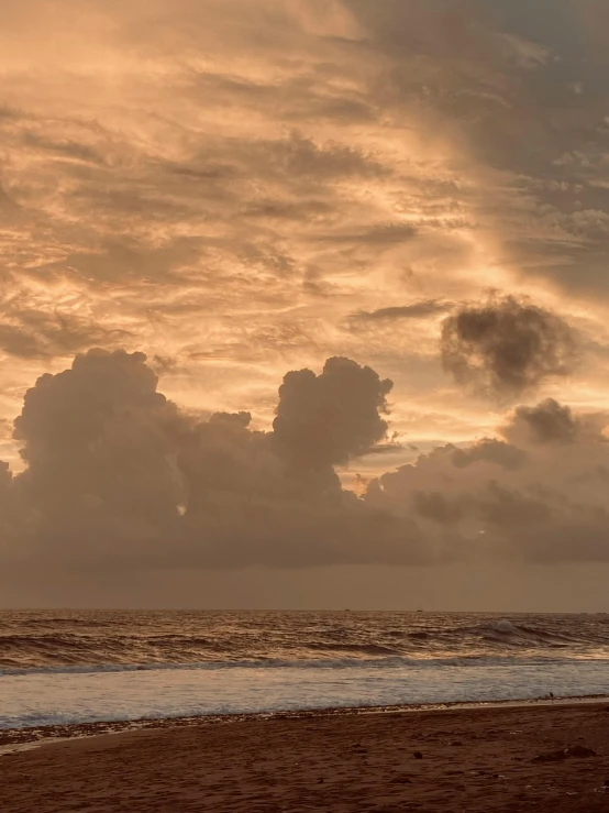 a sandy beach under cloudy skies on an overcast day