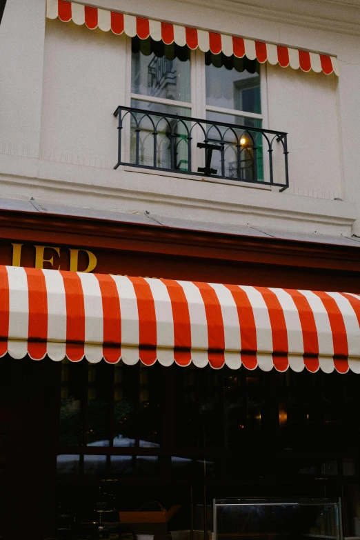 an orange and white awning a store front