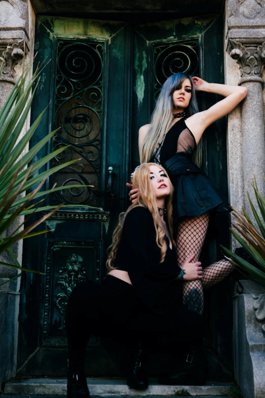 two young women posing for a picture outside a door