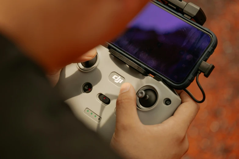 a person holding a game controller to a smart phone