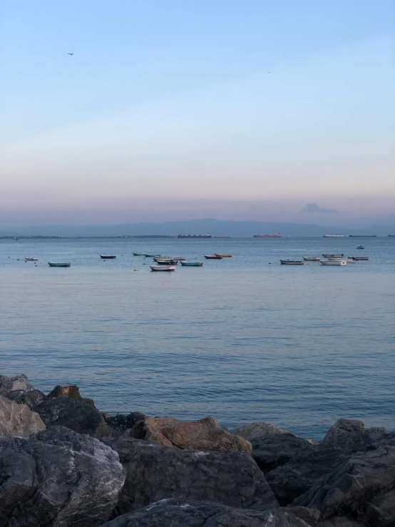 the boats are floating in the water by the shore