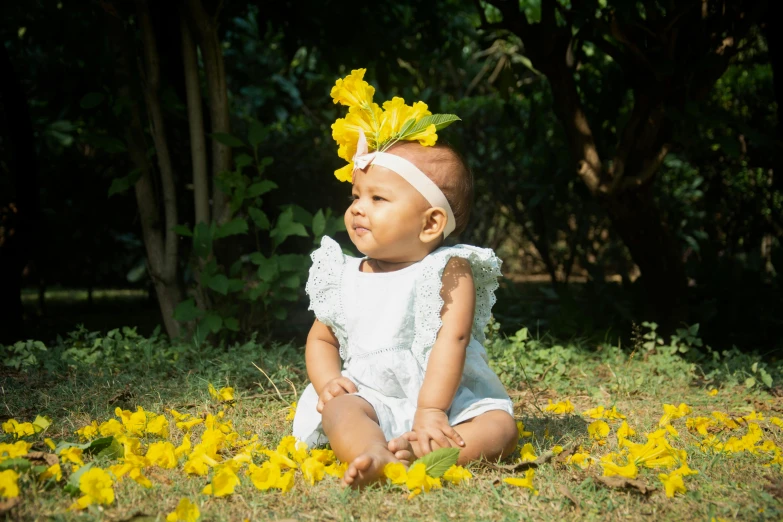 the baby has a yellow flower on her hair