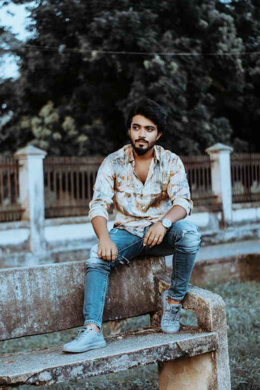 a person sitting on a cement bench with an intense look