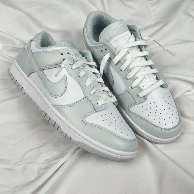 white and gray sneakers are laying on a bed