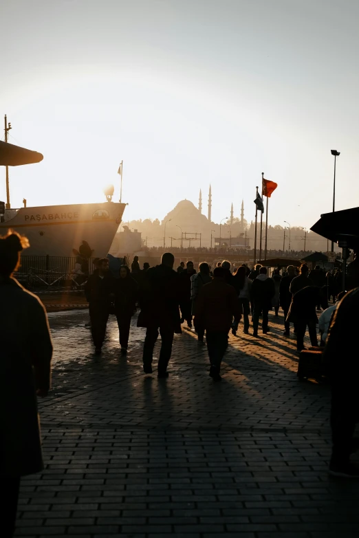 people walking along the waterfront with a cityscape in the background