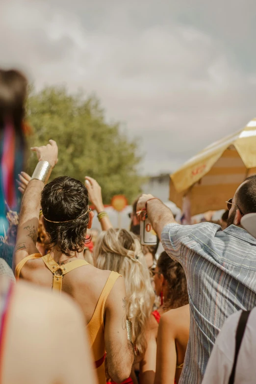 a lot of people stand in the crowd while one person takes a picture