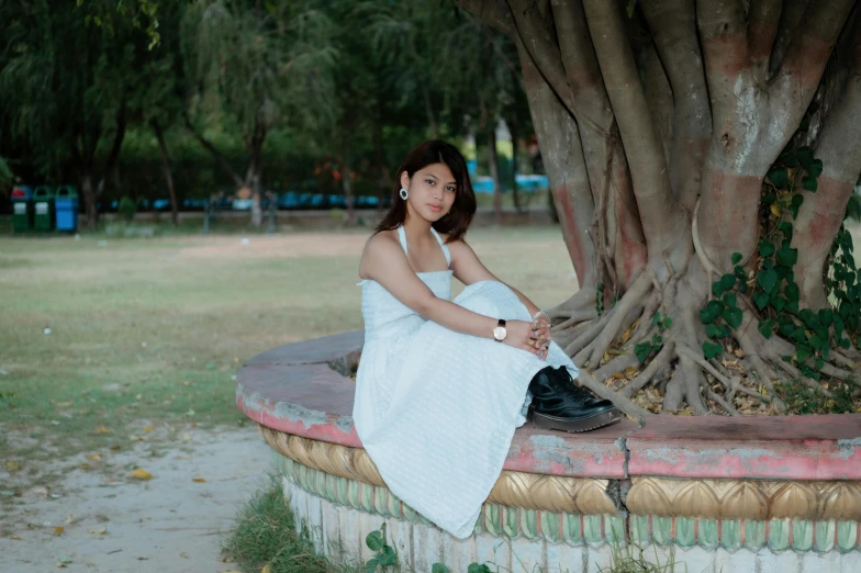 a woman in white dress sitting on the wall