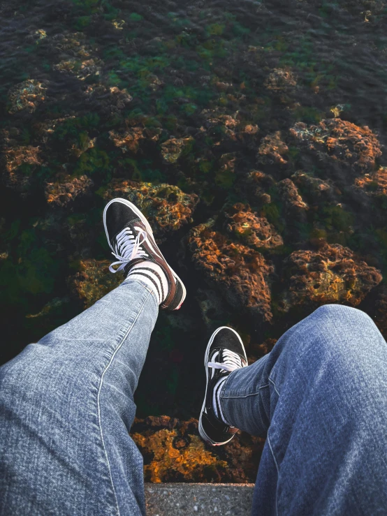 a person is standing on a ledge with their feet up