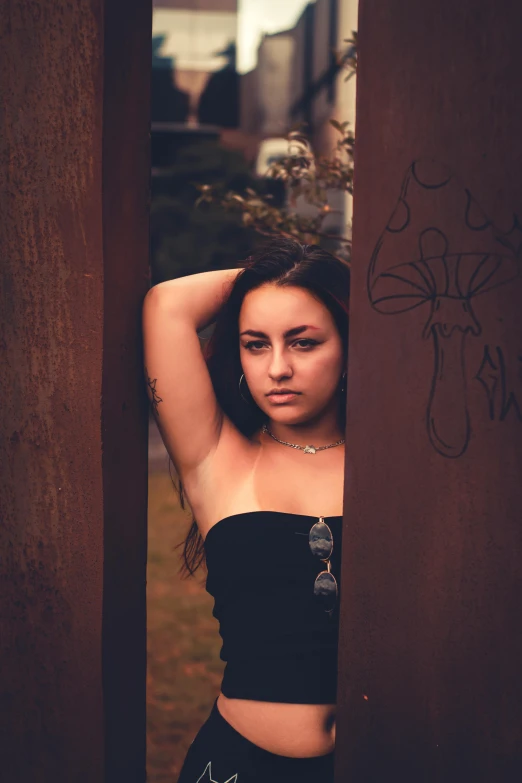 a young woman poses for a po near graffiti