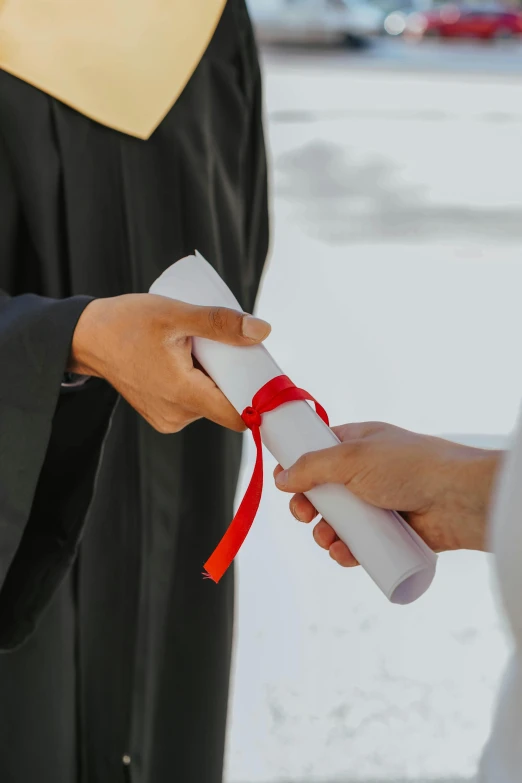 a graduate holding a diploma in his hand