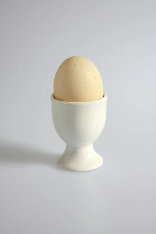 a white cup with an egg inside it