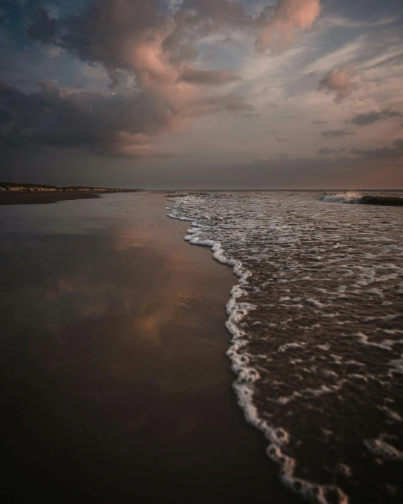 a view of an ocean shore with waves coming in