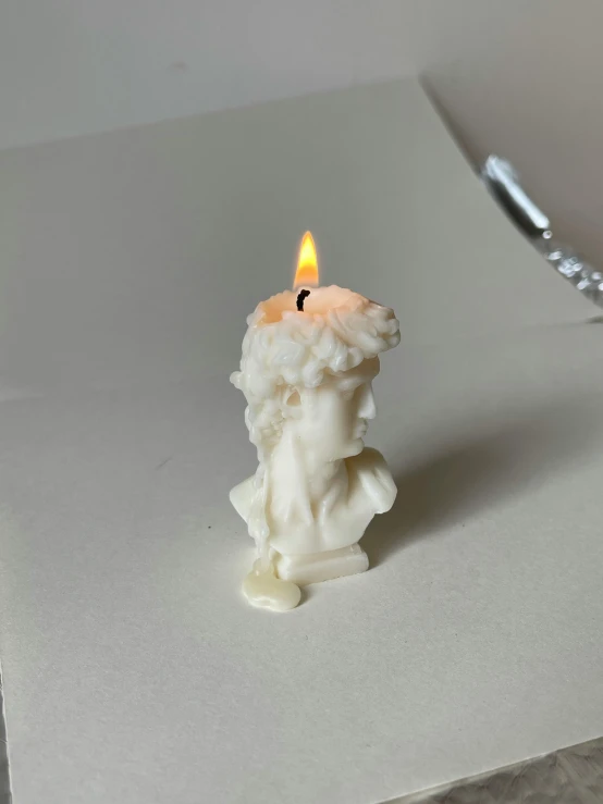 a lit candle sitting on top of a table