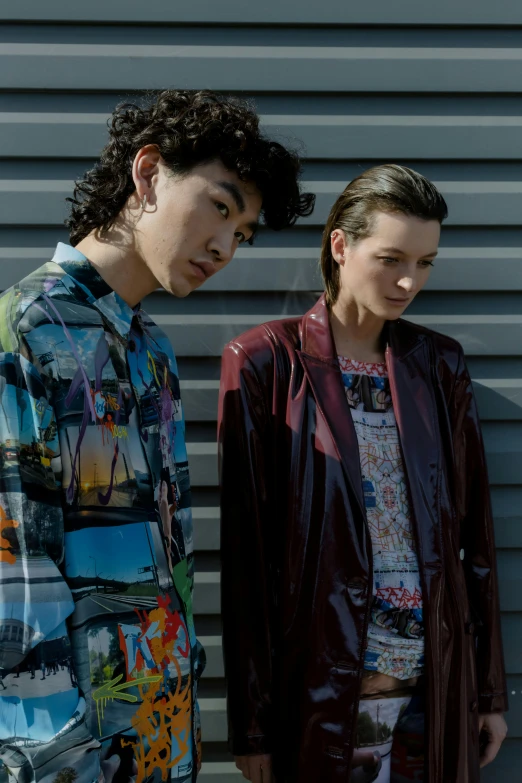 two young men standing next to each other wearing jackets