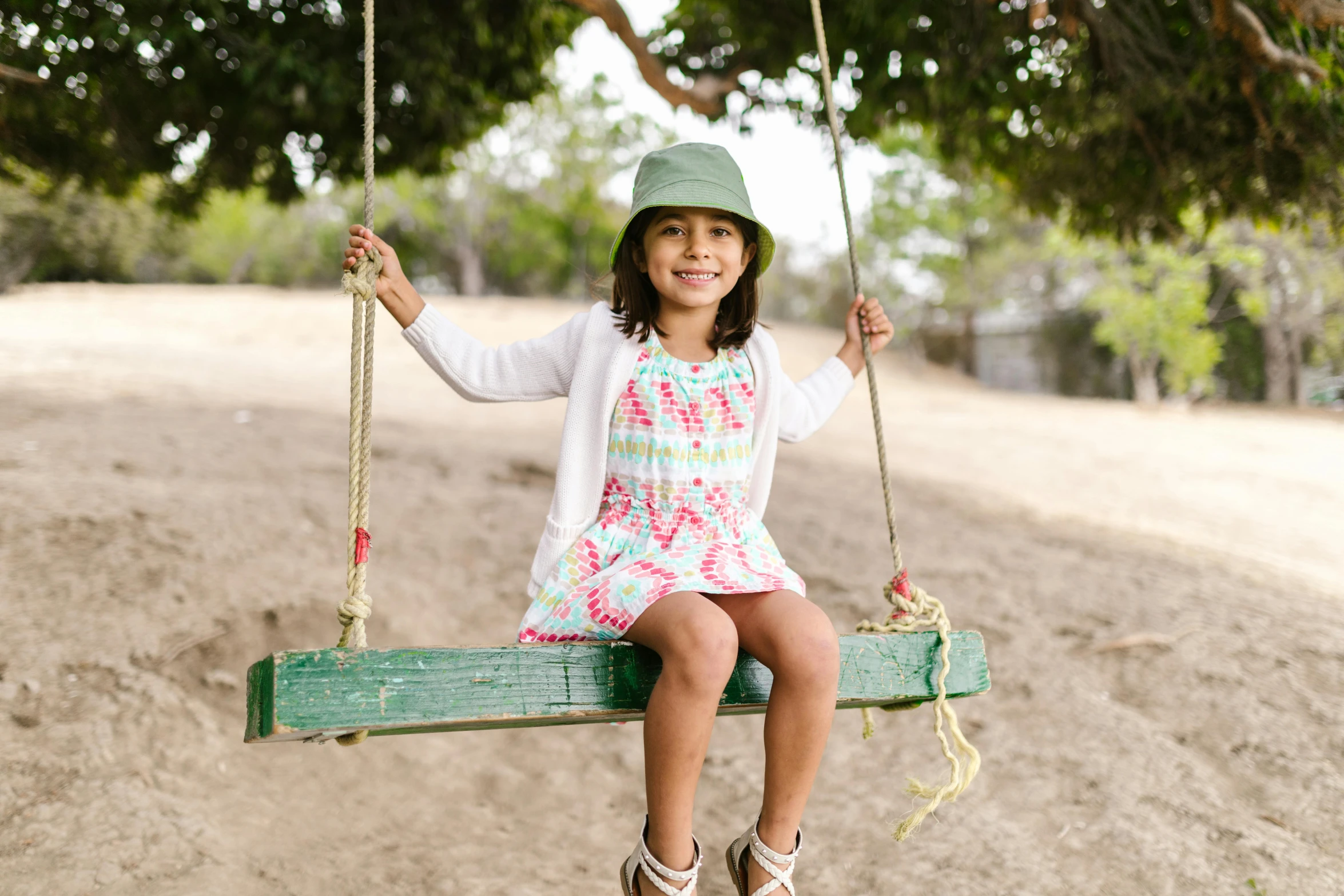 a  is sitting on a green wooden swing