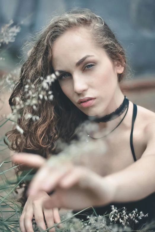 a woman sitting down next to some grass