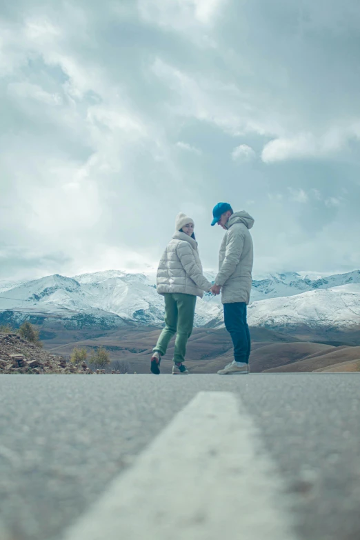 a young man and woman standing on top of a rocky hill