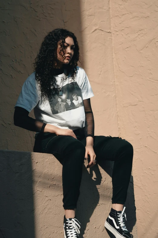 a young woman is sitting on the ledge and looking straight ahead