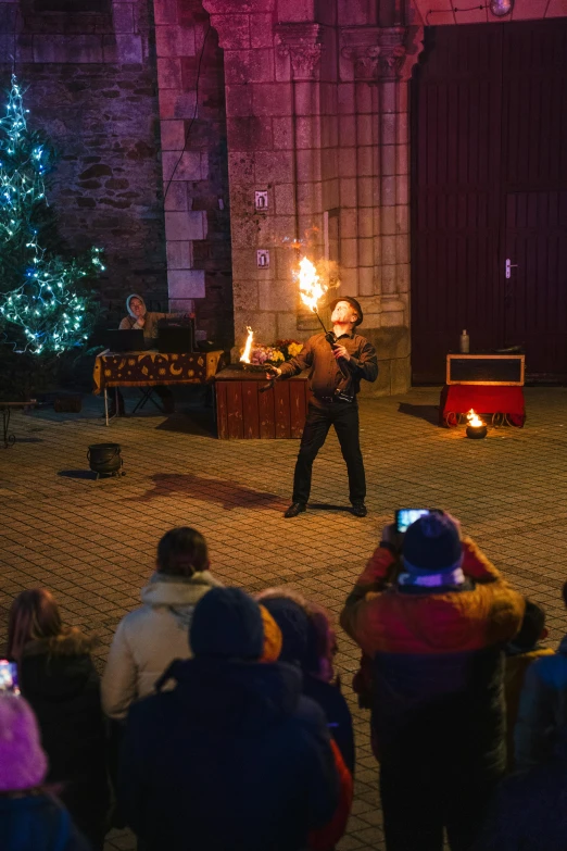 an individual is performing at a gathering in the night