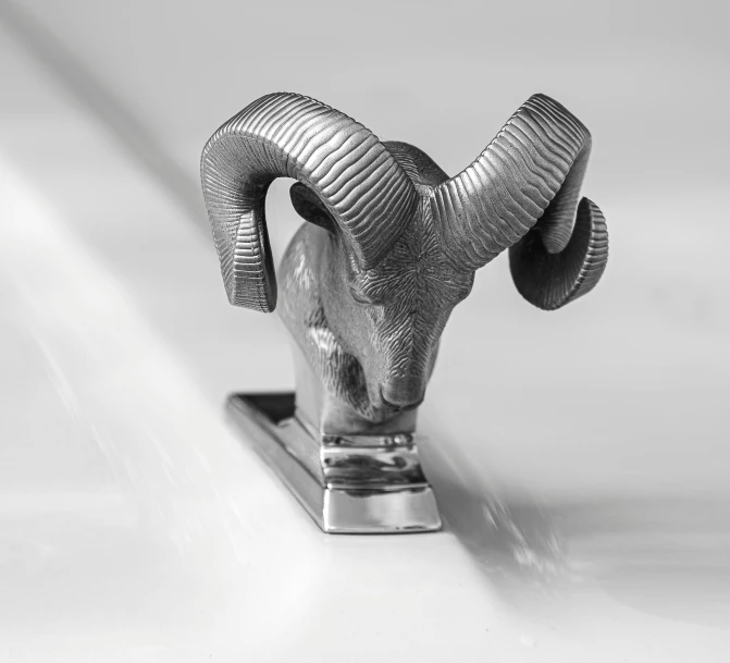 the head of a ram sculpture sitting on top of a chrome block