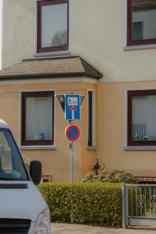 a no parking sign stands outside of an apartment building