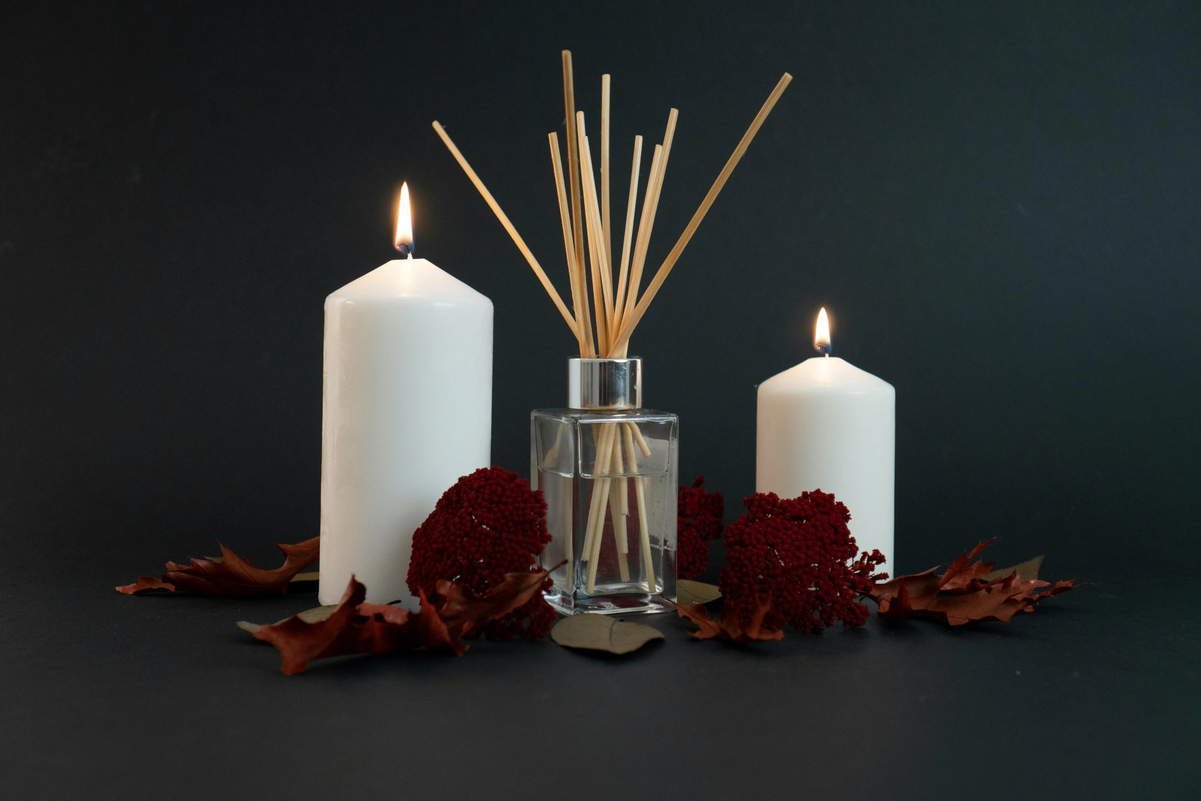 three tall candles sitting on top of a table