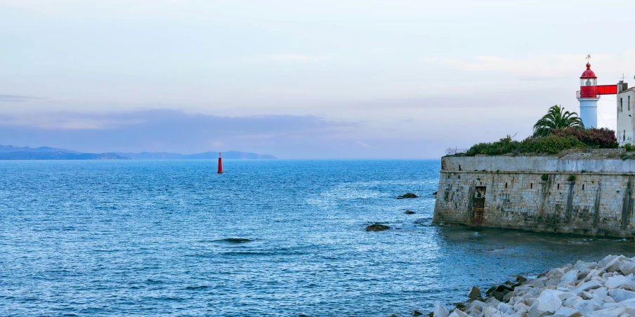 a lighthouse on top of a cliff in the ocean