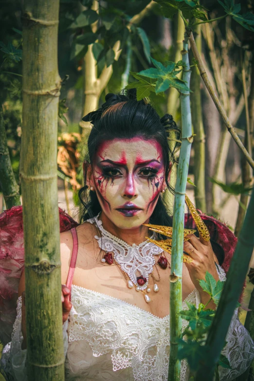 a woman dressed up as a fairy in the forest