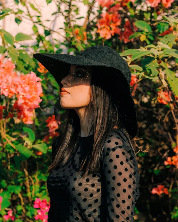 a young woman wearing a hat and a sheer top