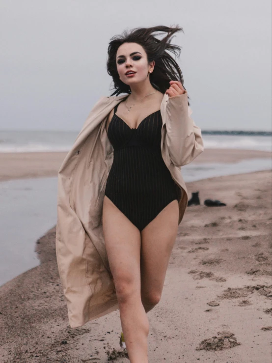 a woman is posing for a picture in a bathing suit on the beach