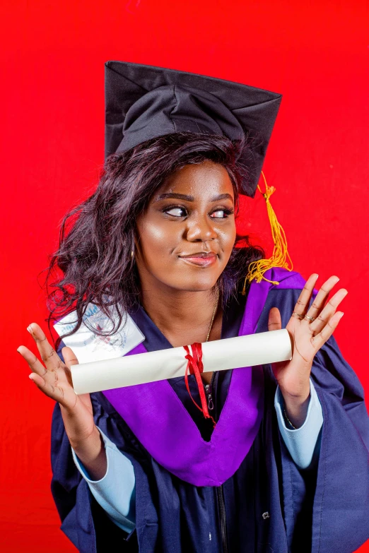 a woman in graduation gown is holding up a graduation scroll